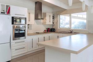 een keuken met witte kasten en een wit aanrecht bij Spahaus Getaway on Morris in Mornington +14 foto's