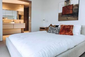 a bedroom with a large white bed and a bathroom at Spahaus Getaway on Morris in Mornington