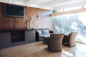 a living room with wicker chairs and a flat screen tv at Spahaus Getaway on Morris in Mornington