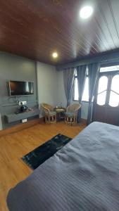 a bedroom with a bed and a flat screen tv at Pahari Soul in Darjeeling