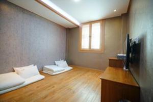 a room with two white beds and a television at Gamyoungroo Hanok Hotel in Jeonju +17 photos