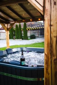 a hot tub with two glasses and a bottle of wine at Casa de Vacanta Diana Turnu Rosu in Turnu Roşu