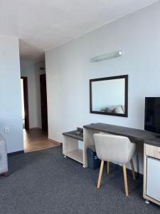 a living room with a desk and a television at Family Hotel Sunrise in Lozenets