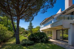 an exterior view of a house with a tree at Villa Carla house with hot tub and beautiful garden in Ičići