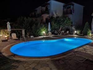 a large blue swimming pool at night at Guesthouse Christos in Skopelos Town +32 photos