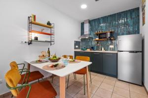 a kitchen with a white table and a refrigerator at Labarbara Palamós Apartament in Palamós