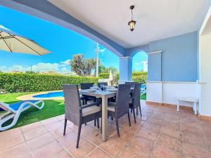 a dining room with a table and chairs and a pool at Mar Menor Golf Villa - 6310 in Torre-Pacheco