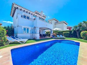 a villa with a swimming pool in front of a house at Mar Menor Golf Villa - 6310 in Torre-Pacheco