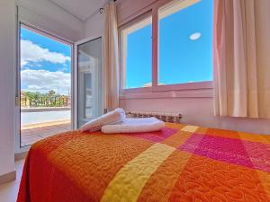 a bedroom with a colorful bed and large windows at Mar Menor Golf Villa - 6310 in Torre-Pacheco