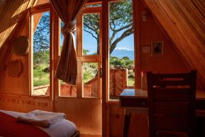 Giường trong phòng chung tại Olemayian Amboseli Cottages