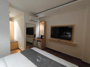 a hotel room with a bed and a flat screen tv at Hotel Pavilion in Mussoorie