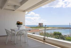 a balcony with a table and chairs and a view of the ocean at Casa Dansodà sul mare in Torre Lapillo