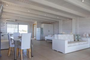 a kitchen and living room with a couch and a table at Casa Dansodà sul mare in Torre Lapillo +8 photos