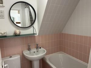 a bathroom with a sink and a toilet and a mirror at Chalet 126 in Deal