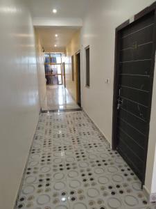 a hallway with a tile floor and a door at Hotel Dev Inn Ayodhya in Ayodhya