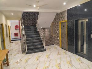 a staircase in a room with a marble floor at Hotel Dev Inn Ayodhya in Ayodhya
