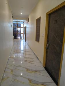 an empty hallway with a door and a tile floor at Hotel Dev Inn Ayodhya in Ayodhya