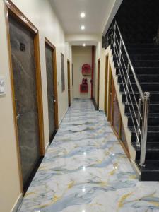 a hallway with a tile floor and stairs at Hotel Dev Inn Ayodhya in Ayodhya