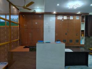 a room with wooden lockers and a white refrigerator at Hotel Dev Inn Ayodhya in Ayodhya