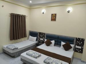 a bedroom with two beds and a window at Hotel Dev Inn Ayodhya in Ayodhya