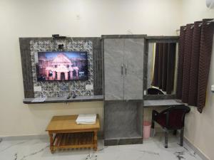 a living room with a tv on a wall at Hotel Dev Inn Ayodhya in Ayodhya
