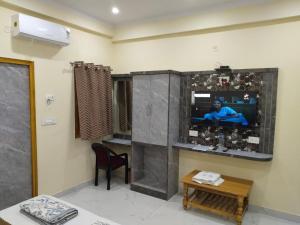 a living room with a tv on a wall at Hotel Dev Inn Ayodhya in Ayodhya