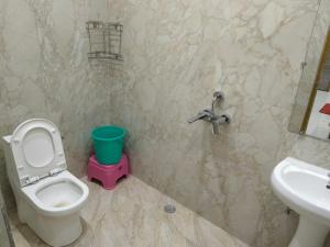 a bathroom with a toilet and a sink at Hotel Dev Inn Ayodhya in Ayodhya