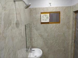 a bathroom with a sink and a glass shower at Hotel Dev Inn Ayodhya in Ayodhya