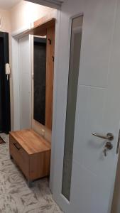 a bathroom with a mirror and a wooden cabinet at Апартамент Плажен рай in Burgas City