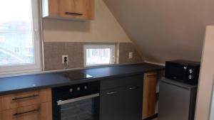 a kitchen with a black counter top and a microwave at Апартамент Плажен рай in Burgas City