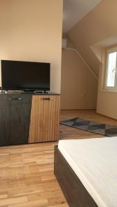 a room with a flat screen tv and a bed at Апартамент Плажен рай in Burgas City