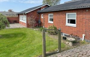 a brick house with a fence in the yard at Gorgeous Home In Spøttrup With Wifi in Spottrup