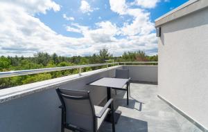 Un patio con una mesa y sillas en un balcón. en Lovely Apartment In Pridraga With Wifi, en Pridraga