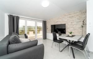 Una sala de estar con un sofá y una mesa con sillas. en Lovely Apartment In Pridraga With Wifi, en Pridraga