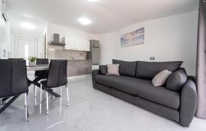 Una sala de estar con un sofá y una mesa con sillas. en Lovely Apartment In Pridraga With Wifi, en Pridraga