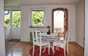 a dining room with a white table and chairs at 1 Bedroom Beautiful Home In Limhamn in Limhamn