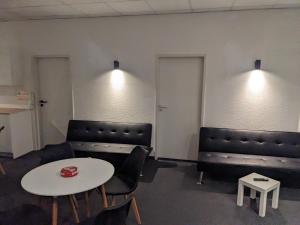 a room with couches and a table and chairs at Zentrales Boardinghouse MG Rheydt in Mönchengladbach
