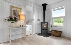a white room with a fireplace and a bedroom at 4 Bedroom Lovely Home In Rønde in Rønde