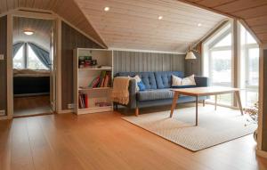 un soggiorno con un divano blu e un tavolo di 4 Bedroom Cozy Home In Færvik a Færvik Altre 13 foto