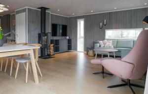 un soggiorno con un divano, un tavolo e delle sedie di 4 Bedroom Cozy Home In Færvik a Færvik