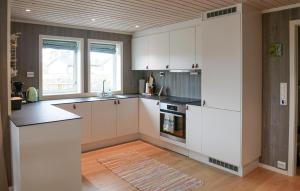 una cucina con mobili bianchi e pavimento in legno di 4 Bedroom Cozy Home In Færvik a Færvik