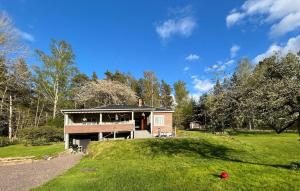 a house with a porch on a grassy field at Pet Friendly Home In Söderköping in Söderköping +30 photos