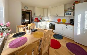 a kitchen with a wooden table with chairs and a kitchen with white cabinets at Pet Friendly Home In Söderköping in Söderköping
