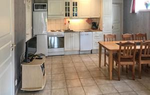 a kitchen with white appliances and a table and chairs at Nice Apartment In Sälen With Sauna in Sälen
