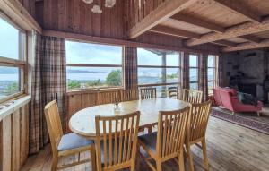 a dining room with a table and chairs and windows at Lovely Home In Masfjordnes With Sauna in Sørkvingo