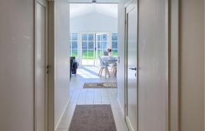 a person working at a desk in a room with a hallway at Gorgeous Home In Färjestaden in Färjestaden