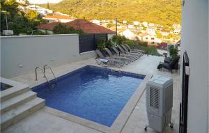 a swimming pool with lounge chairs next to a building at Awesome Apartment In Korcula With Sauna in Korčula