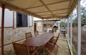 a wooden table and chairs on a patio at Gorgeous Home In Acate in Acate