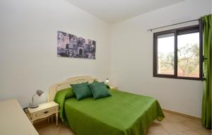 a bedroom with a green bed and a window at Gorgeous Home In Acate in Acate