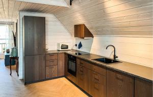 a kitchen with wooden cabinets and a sink at 3 Bedroom Beautiful Home In Sirevåg in Sirevåg